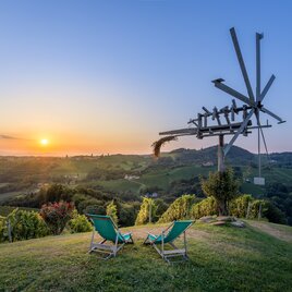 Zwei Liegestühle mit einem traumhaften Panorama auf die Weinberge und ein Klapotetz