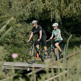 Pärchen genießt Radtour an einem Teich entlang 