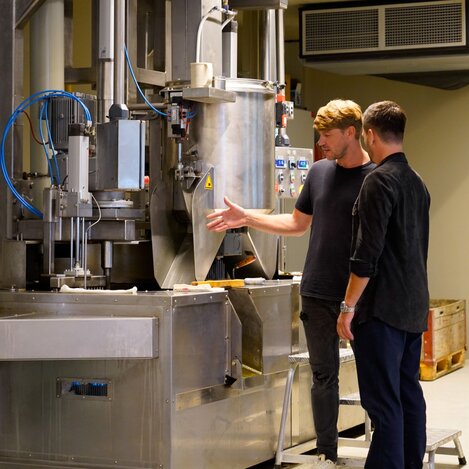 Geschäftsführer der Ölmühle Pronnegg Martin Pronnegg (links) und Heimatleuchten Moderator Richard Deutinger (rechts) in der Kernöl Produktionshalle | © Servus TV | Lena Moik