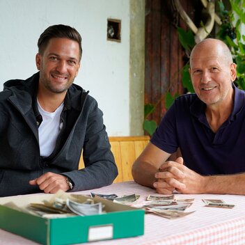 Heimatleuchten Moderator Richard Deutinger (links) und Weinbauer des Bio-Weinguts Knaus (rechts) posieren für ein Foto am Bio-Weingut Knaus | © Servus TV | Lena Moik