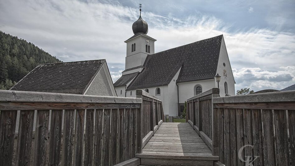 Ein Holzsteg führt zur Kirche in Traboch