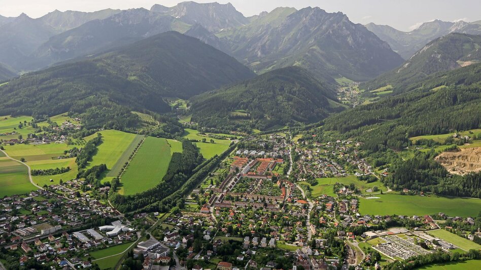 Panorama einer Stadt im Tal umgeben von Gebirge