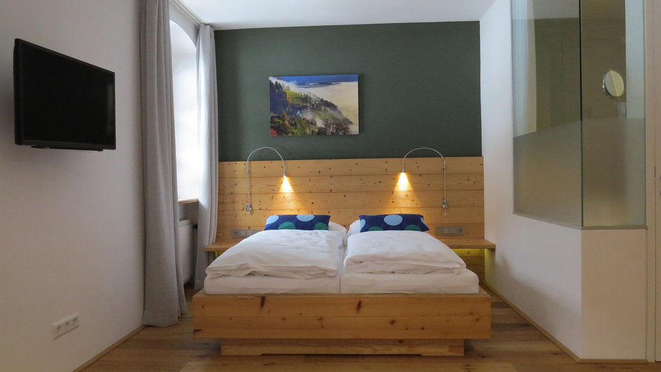 Ein Schlafzimmer mit Doppelbett und einem Fernseher.