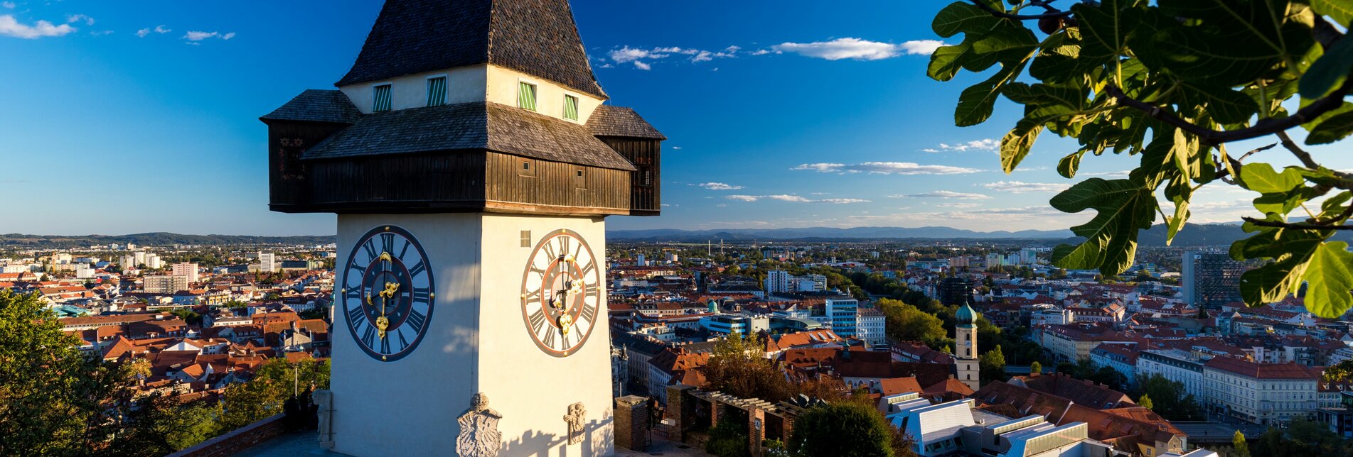 Blick vom Schlossberg mit dem Uhrturm im Vordergrund auf die Dächer von Graz | © Graz Tourismus
