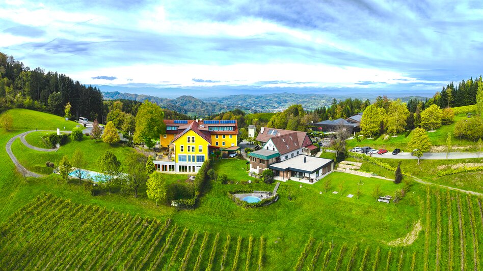Die Luftaufnahme zeigt das Gut Moser in Großwalz in der Gemeinde Leutschach an der Südsteirischen Weinstraße mit Blick in die sanft-hügelige Südsteiermark