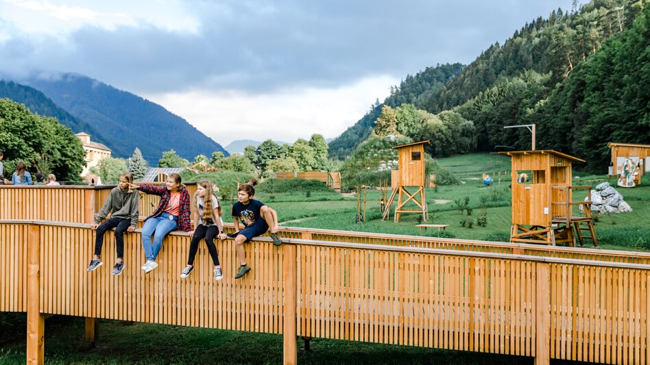 Kinder auf einer Holzbrücke im Grünen