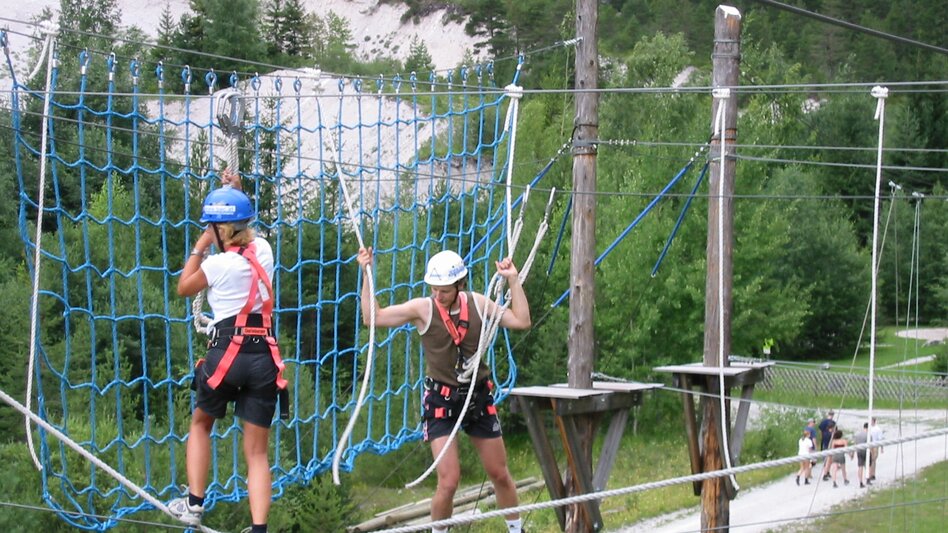 Zwei Personen im Hochseilklettergarten