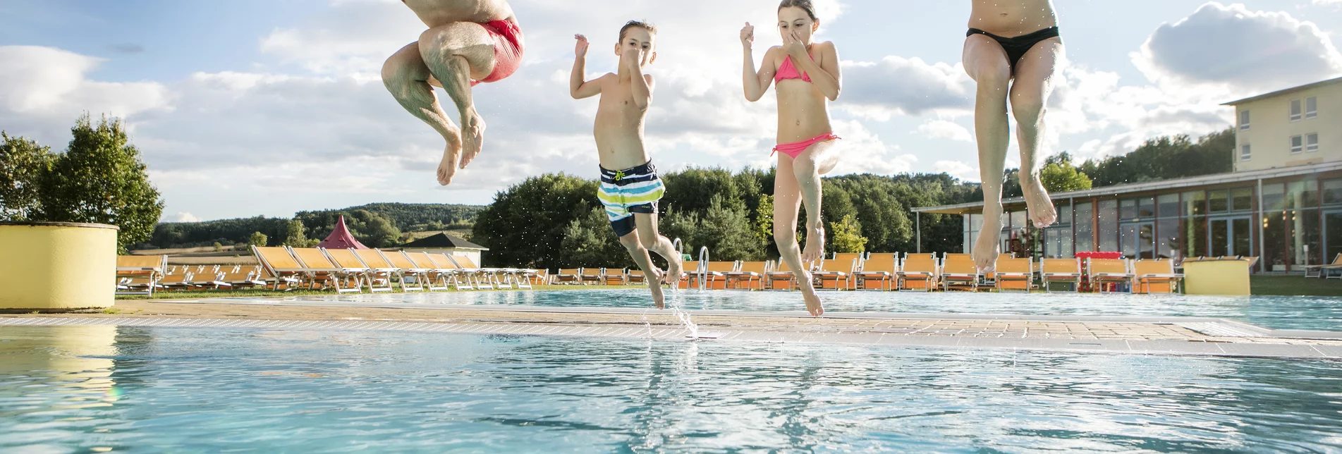 Eine Familie hüpft ins Wasserbecken | © H2O Hoteltherme GmbH