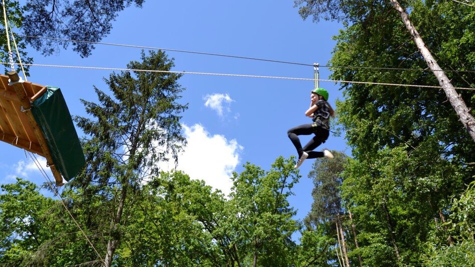 Kind im Hochseilklettergarten auf Flying Fox | © Styrassic Park GmbH