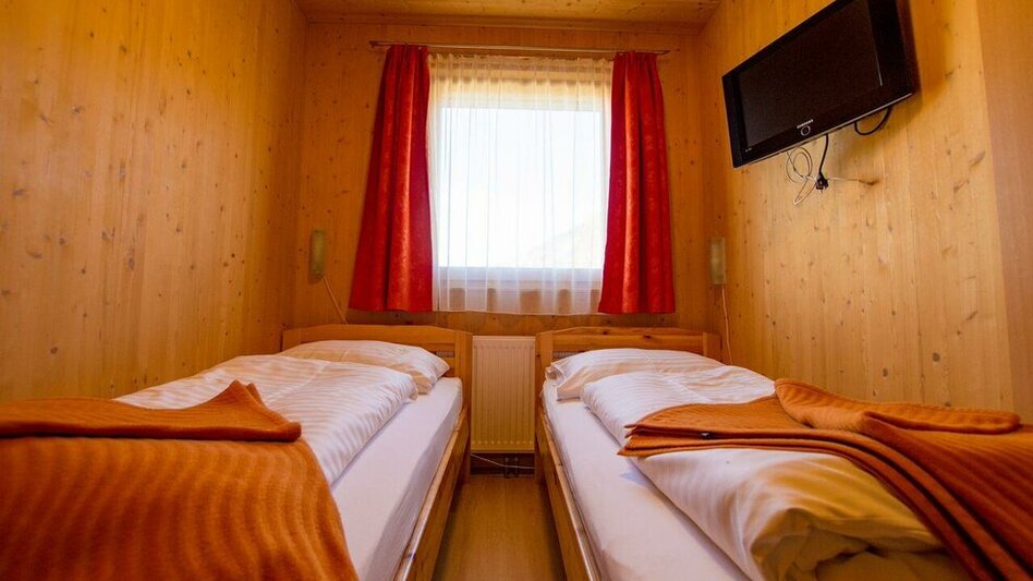 Zimmer im Grebenzenblick. Die zwei Betten sind durch einen kleinen Gang voneinander getrennt.