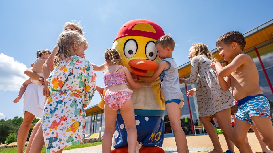 Kinder versammeln sich um HopiHo, dem Maskottchen