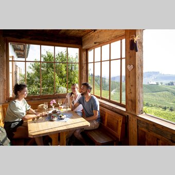 Hiking break at the Buschenschank with a view of the South Styrian vineyards | © Steiermark Tourismus | Tom Lamm