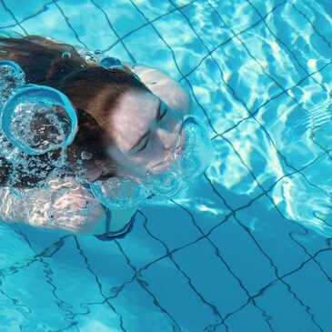 Frau taucht aus dem Wasser auf
