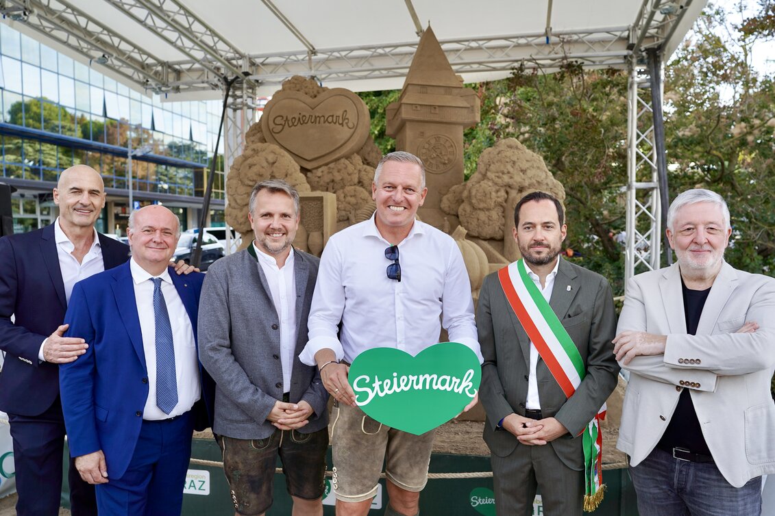 Sechs Personen Sandskulptur von links: Massimo Ambrosin (Kommunalpolitiker), Pierfrancesco Contarini (Präs. Hoteliersvereinigung AJA Jesolo), Michael Feiertag (GF STG), Landeshauptmann Mario Kunasek, Christofer De Zotti (Bürgermeister Jesolo), Angelo Faloppa (Hoteliersvereinigung) vor der Steiermark-Sandskulptur | © STG | Markus Tischhart
