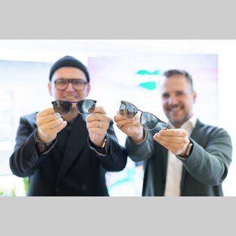 Wolfgang Scheucher (Andy Wolf) und Michael Feiertag (GF Steiermark Tourismus) mit den neuen Steiermark-Sonnenbrillen Andy im Brillenquartier in der Hans-Sachs-Gasse in Graz.  | © STG I Harry Schiffer | Harry Schiffer Photodesign
