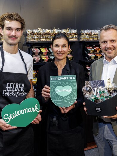 Johannes und Julia Felber gemeinsam mit STG-GF Michael Feiertag im neuen Felber-Shop mit Schokolade-Auswahl. | © STG | Erwin Scheriau