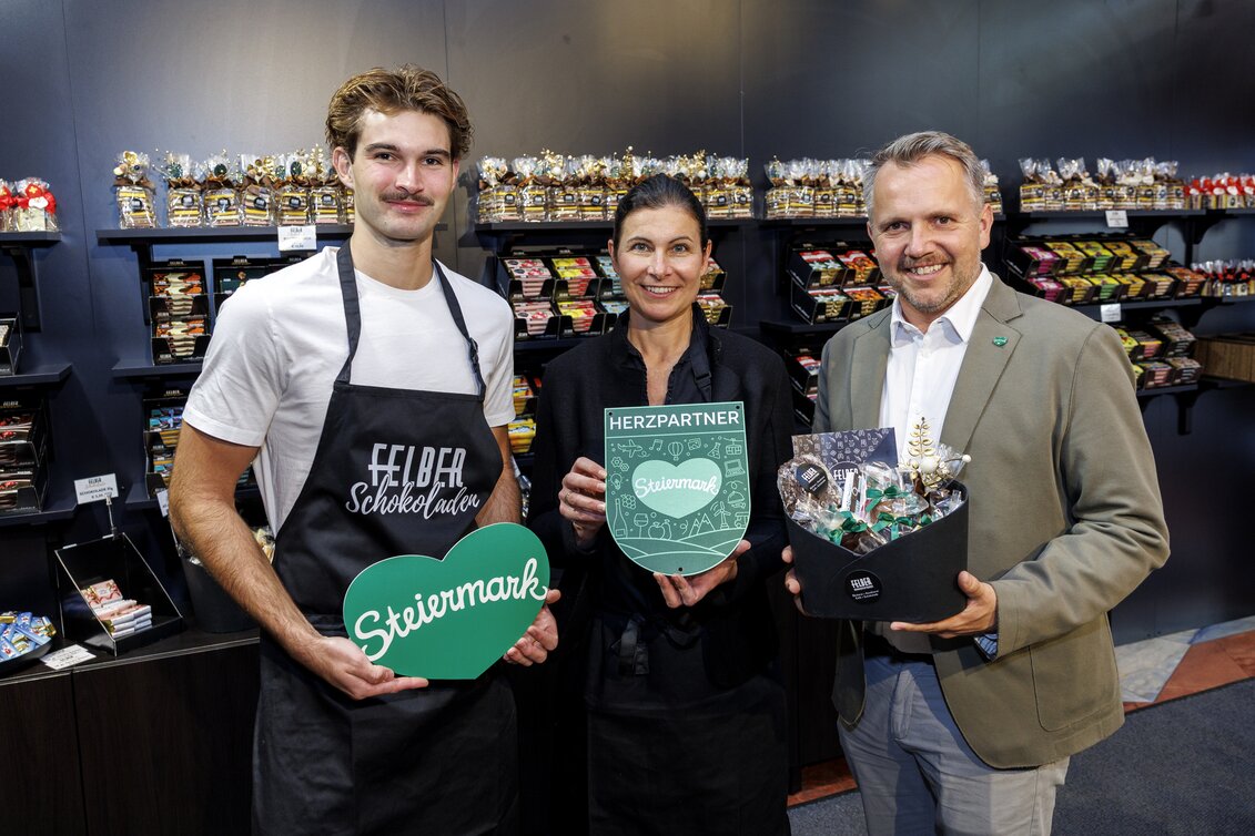 Johannes und Julia Felber gemeinsam mit STG-GF Michael Feiertag im neuen Felber-Shop mit Schokolade-Auswahl. | © STG | Erwin Scheriau