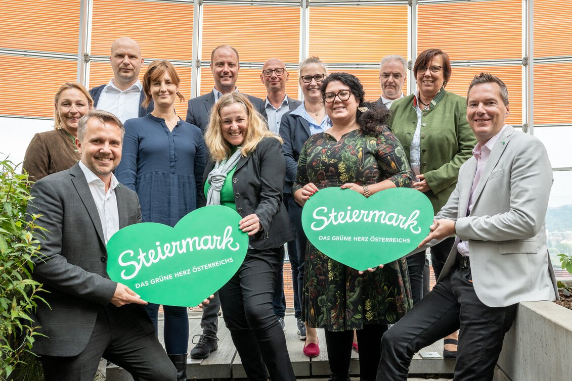 Tourismusbeirat anbei: Die GFs der Erlebnisregionen werden flankiert von STG-GF Michael Feiertag (mit Herz li) und Ingo List, Leiter des Referats Tourismus im Land Steiermark (mit Herz re). Dahinter die GFs Pamela Binder (Ausseerland), Stefan Schindler (Oststeiermark), Jaqueline Egger (Gesäuse), Mathias Schattleitner (Schladming-Dachstein), Claudia Flatscher (Erzberg Leoben), Christian Contola (Thermen- & Vulkanland), Stephanie Zündel (Hochsteiermark), Melanie Koch (Südsteiermark), Peter Mayer (Murau), Manuela Machner (Murtal). | © STG | Jesse Streibl
