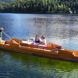 Eine Plätte, ein traditioneller Bootstyp aus dem Ausseerland Salzkammergut, gleitet an einem schönen Sommertag mit einem Plättenführer und zwei Passagieren auf dem malerischen Altausseer See. | © Schifffahrt Altaussee