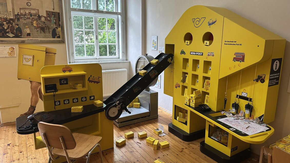 Ein kreatives Spielzimmer mit gelben Spielstationen. Es gibt einen Tisch mit einer Fördereinrichtung und verschiedenen Spielmaterialien. | © Mandl
