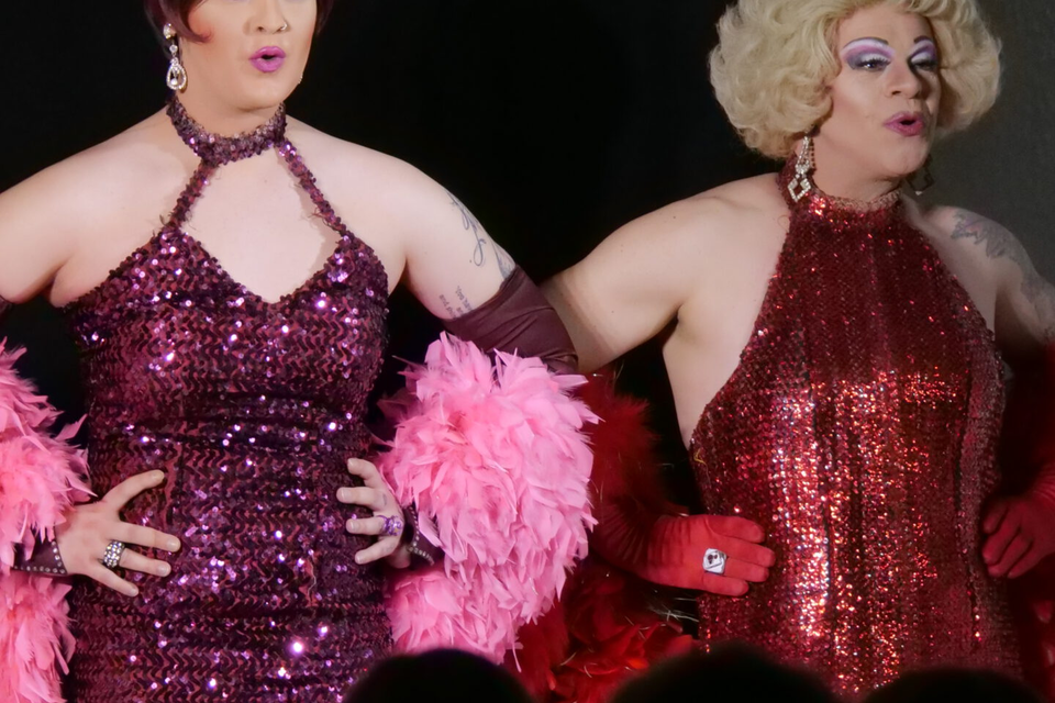 Fünf Drag-Queens posieren in auffälligen, glitzernden Kleidern und farbenfrohen Federboa. Sie strahlen Freude und Stil aus. | © Kirchenwirt Stubenberg