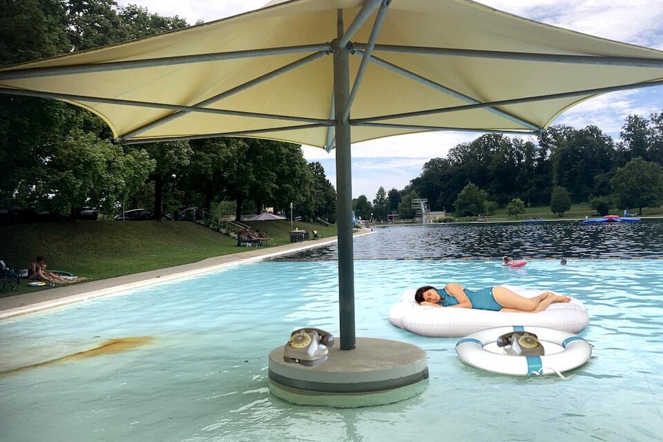 Ein großzügiges Naturbad verbindet kristallklares Wasser mit entspannter Wohlfühlatmosphäre. Schatten spendende Sonnenschirme, gemütliche Schwimm- und Ruhebereiche sowie die weitläufige Parklandschaft laden zum Erholen und Genießen an warmen Sommertagen ein. Kunstinstallation im Freibad Fürstenfeld. | © Glassner&Serasini