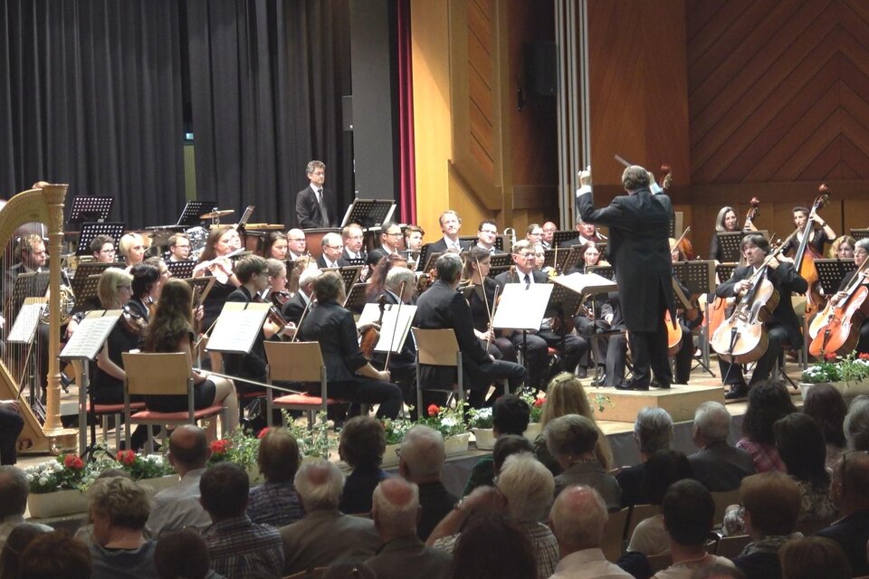 Drei Frauen sitzen auf einer Bank und lächeln. Neben ihnen liegt ein Cello auf dem Boden. | © Waltraud Wachmann