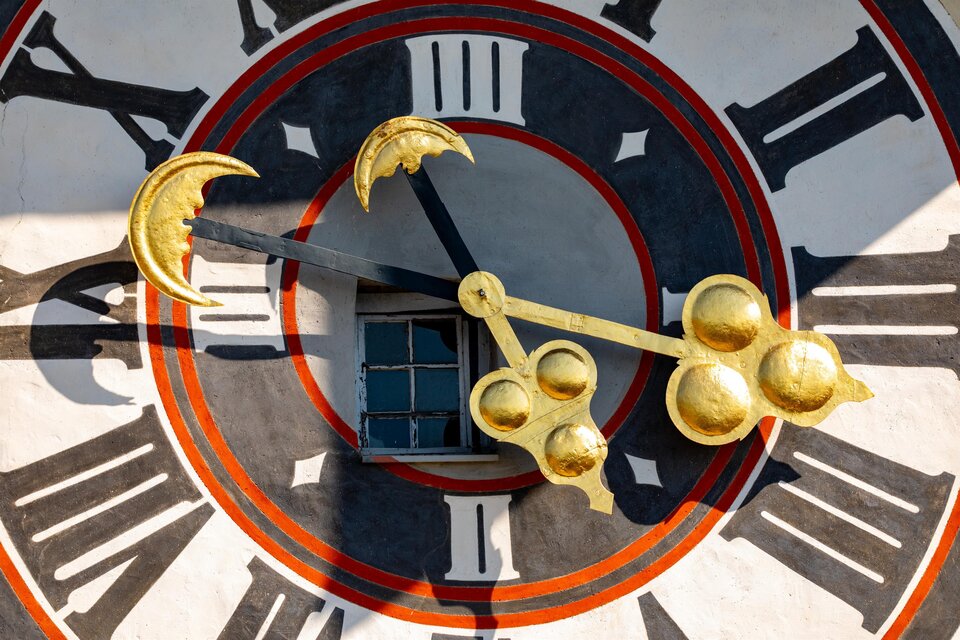Eine große, farbenfrohe Uhr mit goldenen Zeigern und römischen Ziffern. Im Hintergrund befindet sich ein Fenster. | © Graz Tourismus - Harry Schiffer