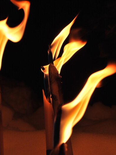 Flammen brennen an mehreren Fackeln in der Dunkelheit. Das Licht erzeugt eine warme und stimmungsvolle Atmosphäre. | © Pixabay