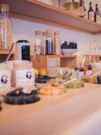Ein hübsches Buffet mit verschiedenen Lebensmitteln und Getränken. Es gibt Gläser mit Müsli, Joghurt, Obst und Säfte. | © Martinhof