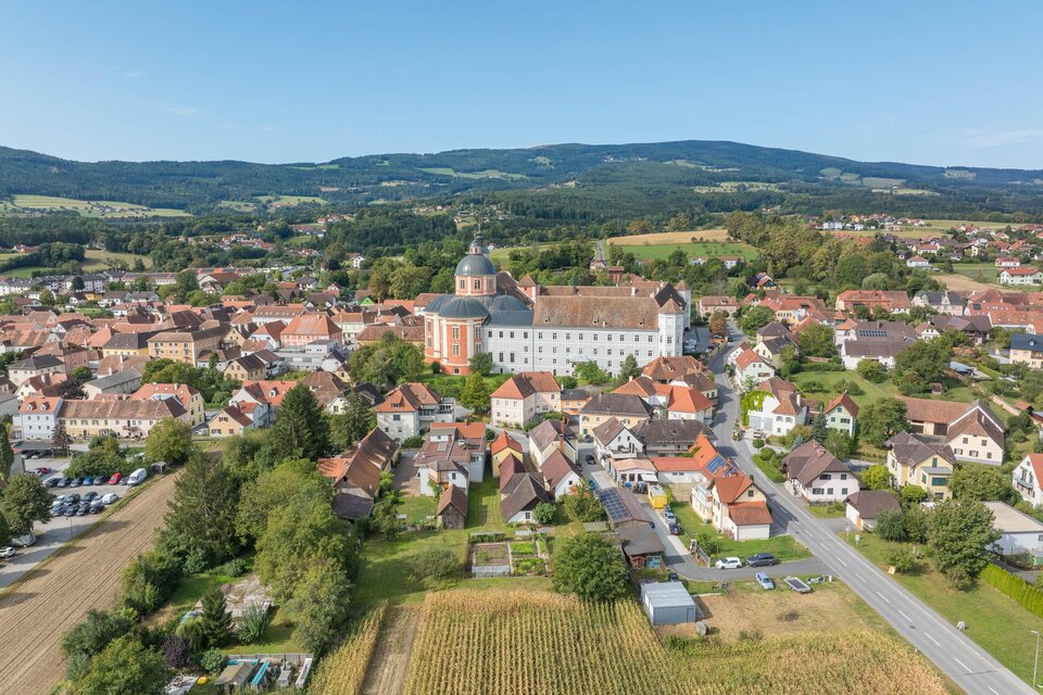 Eine malerische Stadt mit historischen Gebäuden und sanften Hügeln im Hintergrund. Die Landschaft ist grün und einladend. | © Helmut Schweighofer