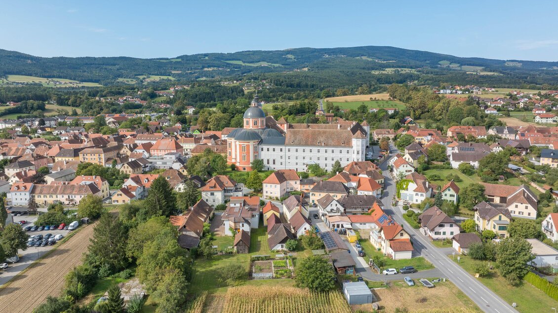 Eine malerische Stadt mit historischen Gebäuden und sanften Hügeln im Hintergrund. Die Landschaft ist grün und einladend. | © Helmut Schweighofer