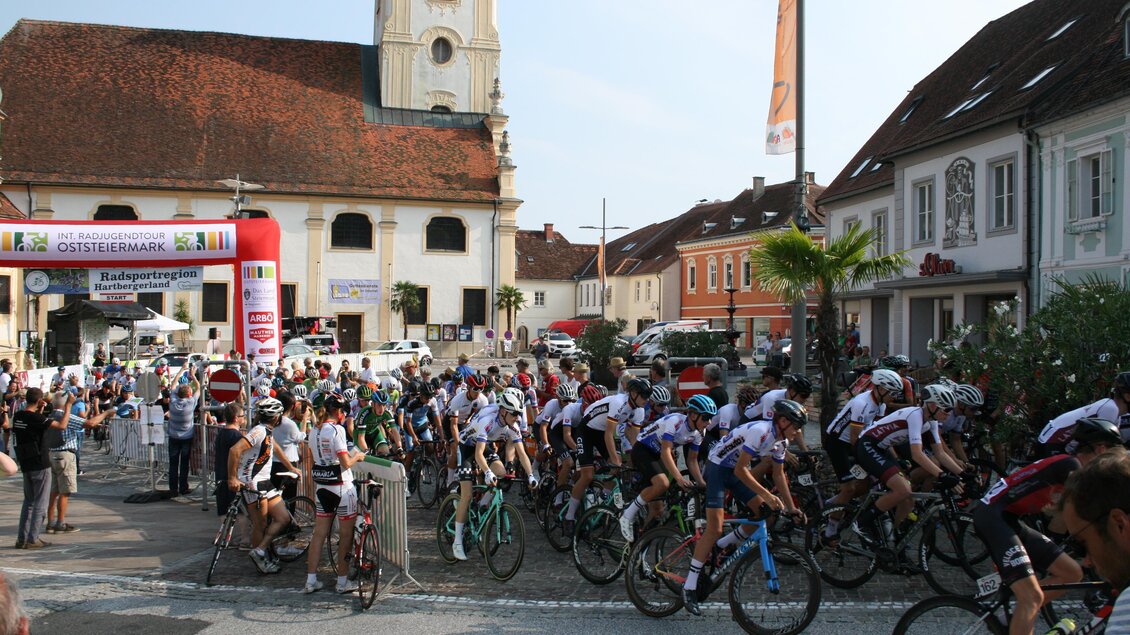 Ein Radrennstart in einer Stadt mit historischen Gebäuden. Viele Radfahrer sind bereit, die Strecke zu fahren. | © Tourismusverband Oststeiermark