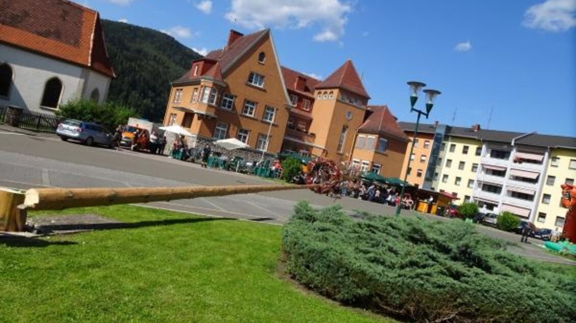 Ein schöner Platz mit mehreren Gebäuden und viel Grün. Im Hintergrund sind Menschen und Stände zu sehen, die eine Veranstaltung anbieten. | © Marktgemeinde Niklasdorf