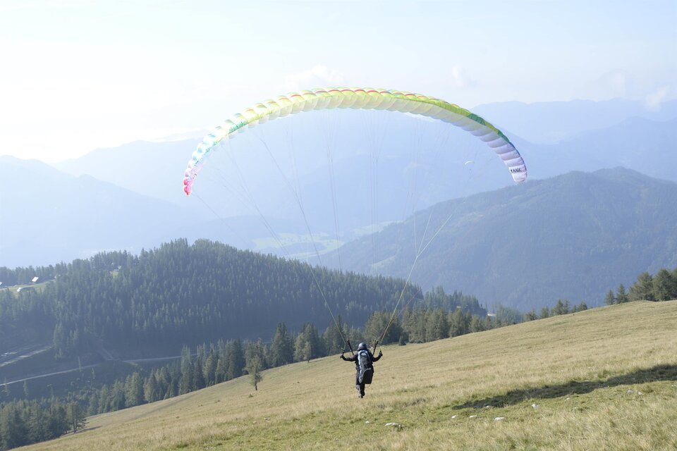 Ein Paraglider  beim Landeanflug auf die Aflenzer Bürgeralm | © Paracenter Austria
