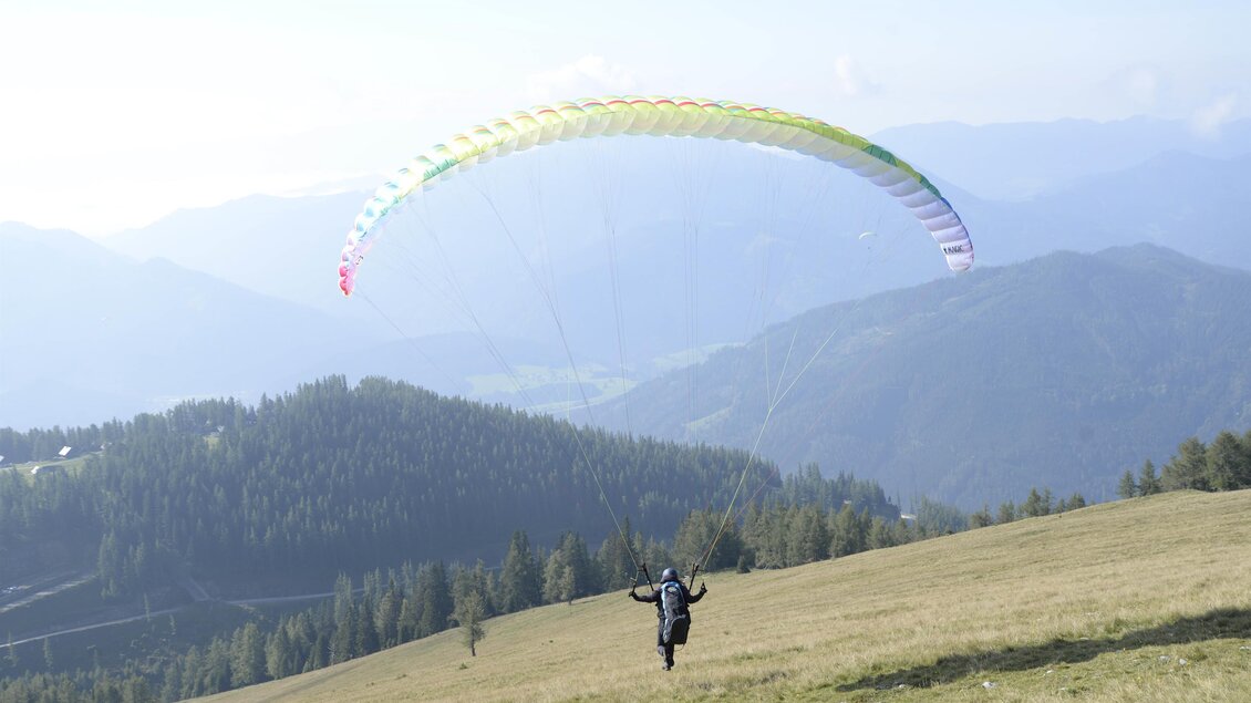 Ein Paraglider  beim Landeanflug auf die Aflenzer Bürgeralm | © Paracenter Austria