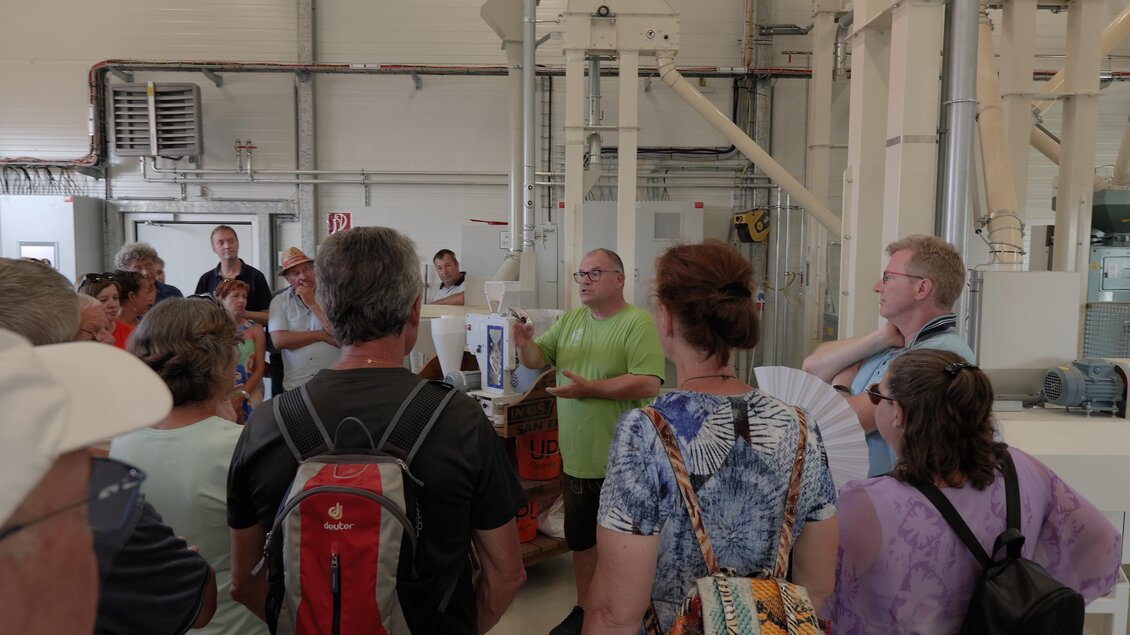 Eine Gruppe von Menschen hört einem Vortrag in einer Fabrik zu. Der Redner steht vorne und erklärt die Abläufe. | © SteirerREISbyFuchs