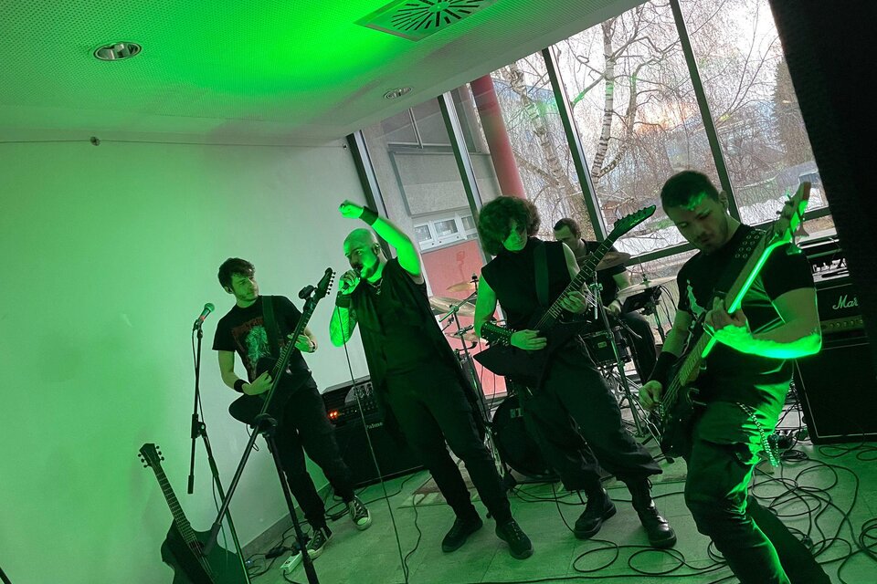 Eine Band spielt live in einem Raum mit grünem Licht. Die Musiker sind intensiv in ihre Performance vertieft. | © Marco Zauner