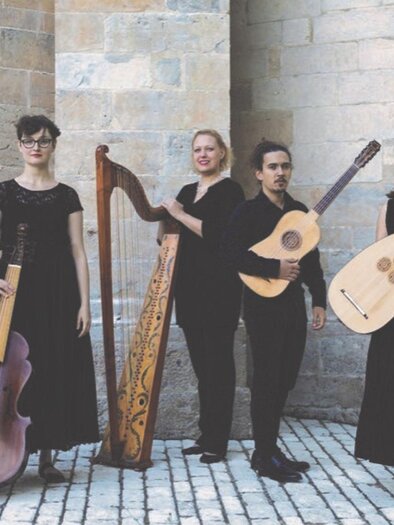 The ensemble Concerto di Margherita from Spain with its five musicians and their various instruments. They are classically dressed in black and are standing in front of a wall in a paved square. | © Vincent Arbeite