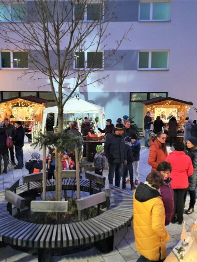 A festive Christmas market with many people gathering around stalls. In the center stands a tree, surrounded by a cozy atmosphere. | © Gemeinde Strallegg