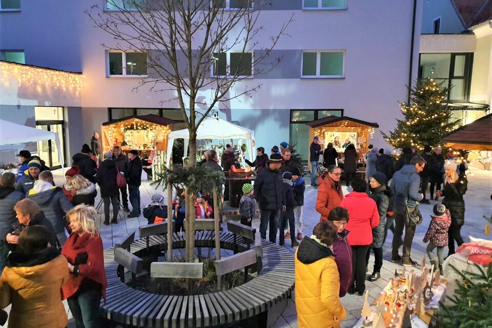 Ein festlicher Weihnachtsmarkt mit vielen Menschen, die sich um Stände versammeln. In der Mitte steht ein Baum, umgeben von einer gemütlichen Atmosphäre. | © Gemeinde Strallegg