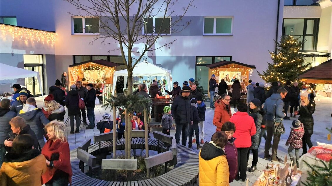 Ein festlicher Weihnachtsmarkt mit vielen Menschen, die sich um Stände versammeln. In der Mitte steht ein Baum, umgeben von einer gemütlichen Atmosphäre. | © Gemeinde Strallegg