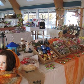 Ein einladender Verkaufsstand mit handgefertigten Dekorationen und Geschenken. Auf den Tischen sind bunte Weihnachtsornamente und verschiedene Kunsthandwerke ausgestellt. | © Gemeinde Wenigzell
