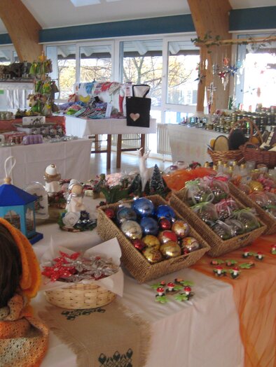An inviting sales booth with handmade decorations and gifts. Colorful Christmas ornaments and various crafts are displayed on the tables. | © Gemeinde Wenigzell