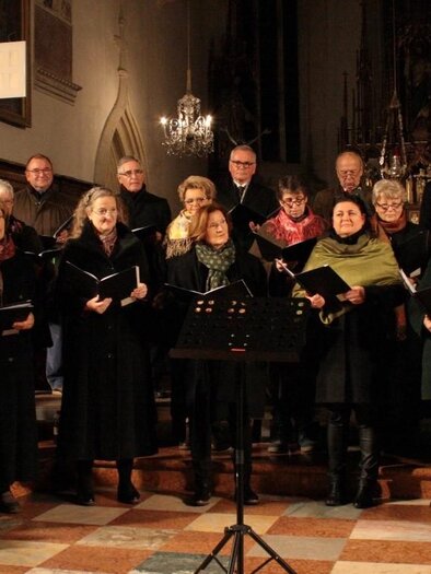 Ein Chor tritt in einer Kirche auf. Die Sängerinnen und Sänger stehen in formeller Kleidung und halten Notenblätter. | © Gesangverein Bad Radkersburg