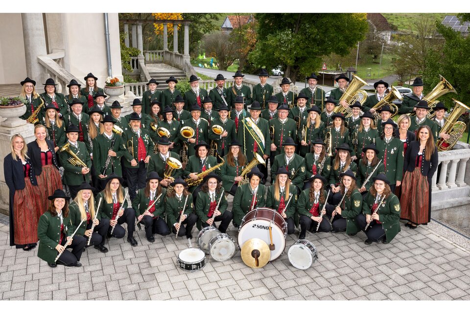 Gruppenfoto des Musikvereins Hatzendorf in traditioneller Tracht mit zahlreichen Musikerinnen und Musikern sowie ihren Blas- und Schlaginstrumenten. | © MV Hatzendorf