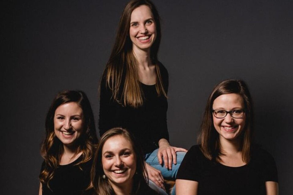 Das Gesangsensemble Puella, mit vier jungen Damen posieren für das Bild. Mit einem schwarzen Hintergrund.   | © Theater & Kultur Premstätten