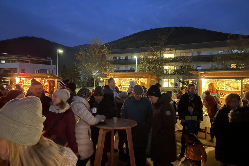 Besucher an beleuchteten Adventständen am Dorfplatz Stattegg bei Einbruch der Dunkelheit. | © Gemeinde Stattegg