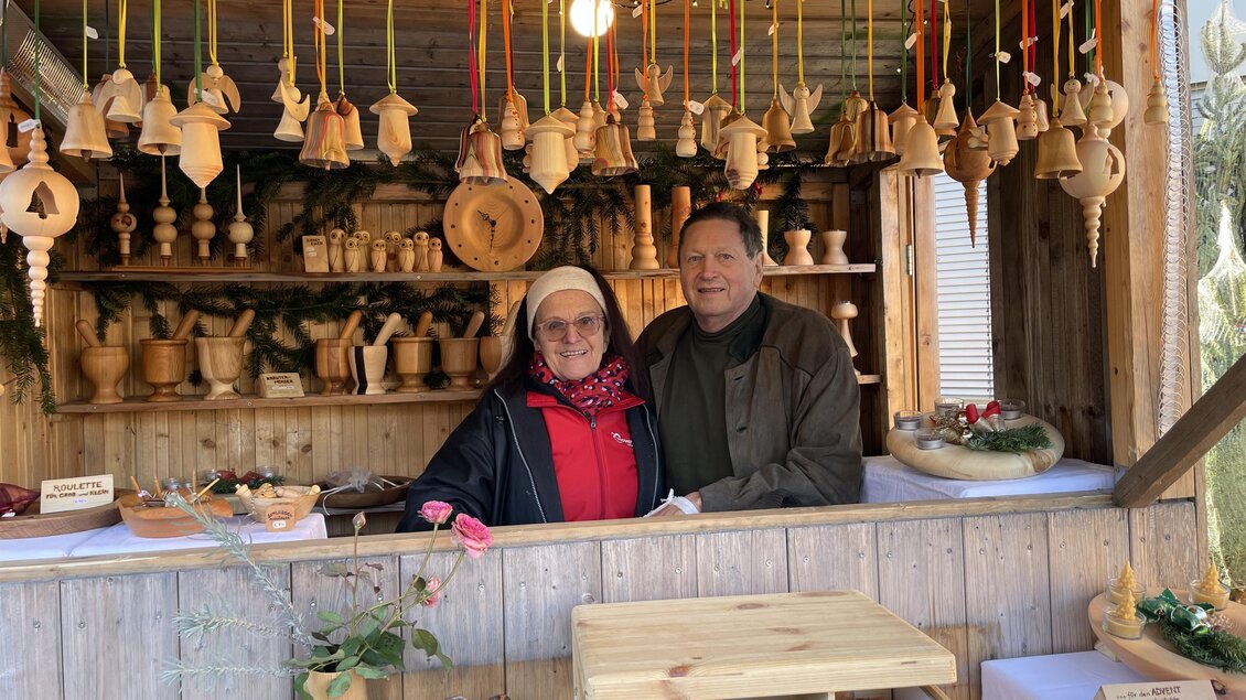 Zwei Aussteller an einem Adventstand in Stattegg mit handgefertigten Holzarbeiten und Weihnachtsdekoration. | © Gemeinde Stattegg