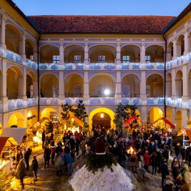 Small wooden huts in the courtyard of Schloss Piber for the sale of crafts and culinary delights, in a pre-Christmas atmosphere. | © Harry Schiffer